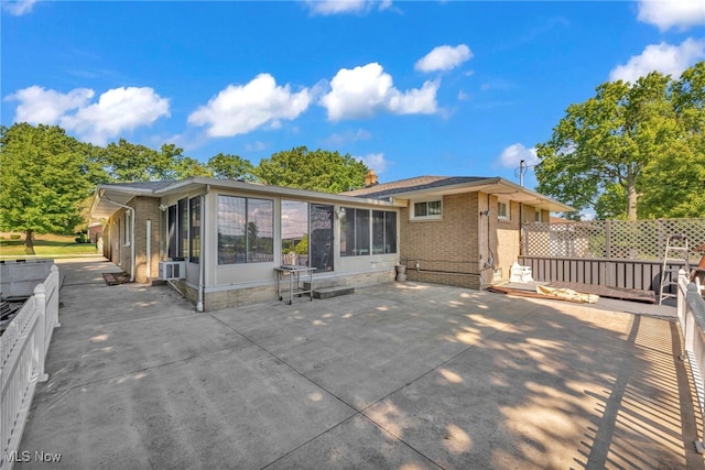 rear view of property with a sunroom and a patio area