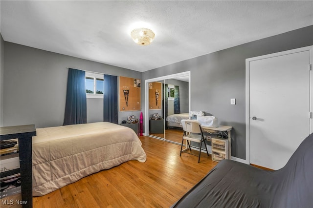 bedroom featuring a textured ceiling, wood-type flooring, and a closet