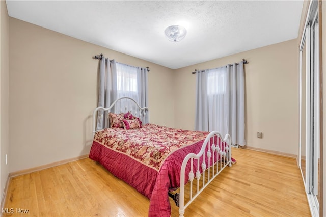 bedroom featuring a textured ceiling and wood-type flooring