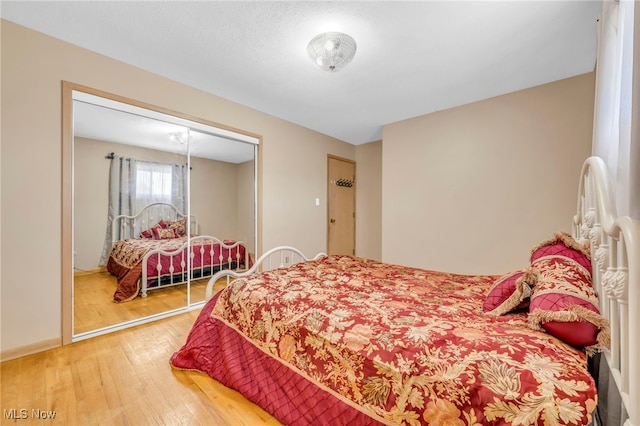 bedroom with a closet and hardwood / wood-style flooring