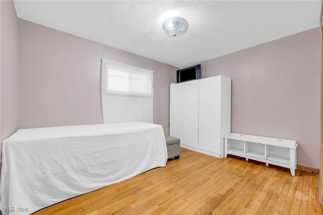 bedroom with hardwood / wood-style flooring and a textured ceiling