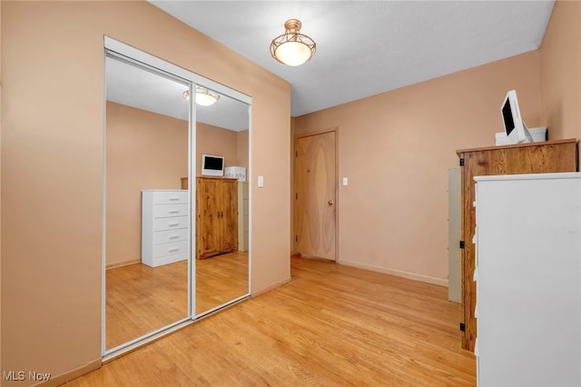 unfurnished bedroom featuring a closet and light hardwood / wood-style floors