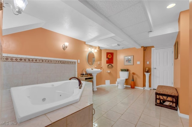 bathroom featuring tile walls, a bathtub, sink, tile patterned floors, and toilet