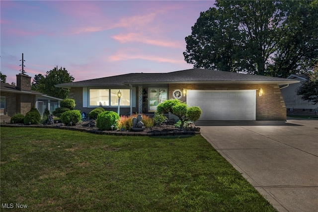 view of front of house with a garage and a lawn