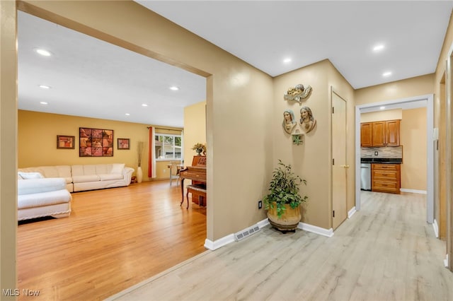 hallway with light hardwood / wood-style floors