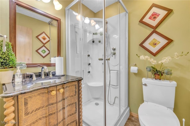 bathroom with tile patterned flooring, vanity, toilet, and a shower with shower door