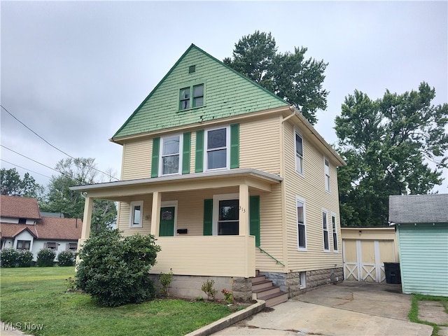 view of front of property with covered porch, a shed, and a front yard