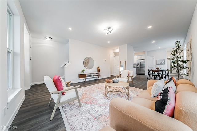 living room featuring dark hardwood / wood-style flooring and a healthy amount of sunlight