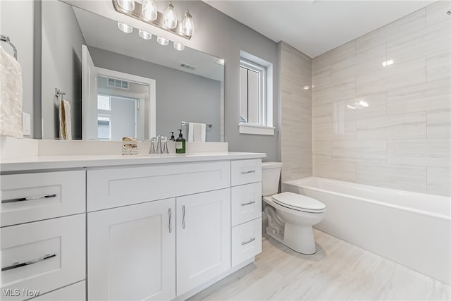 full bathroom with tiled shower / bath combo, vanity, and toilet