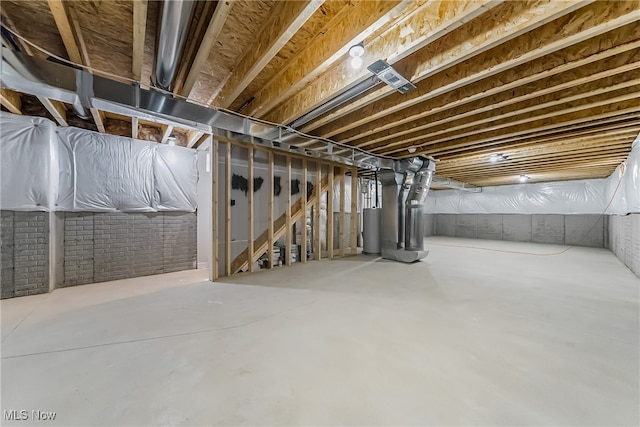 basement featuring heating unit, water heater, and brick wall