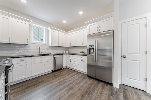 kitchen featuring appliances with stainless steel finishes, dark hardwood / wood-style floors, sink, and white cabinets