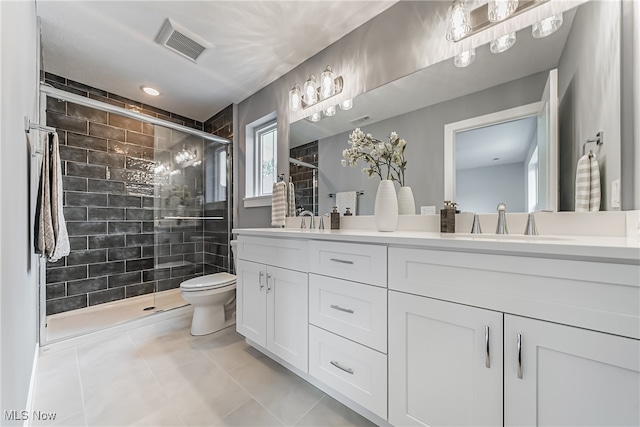 bathroom featuring tile patterned flooring, a shower with shower door, vanity, and toilet