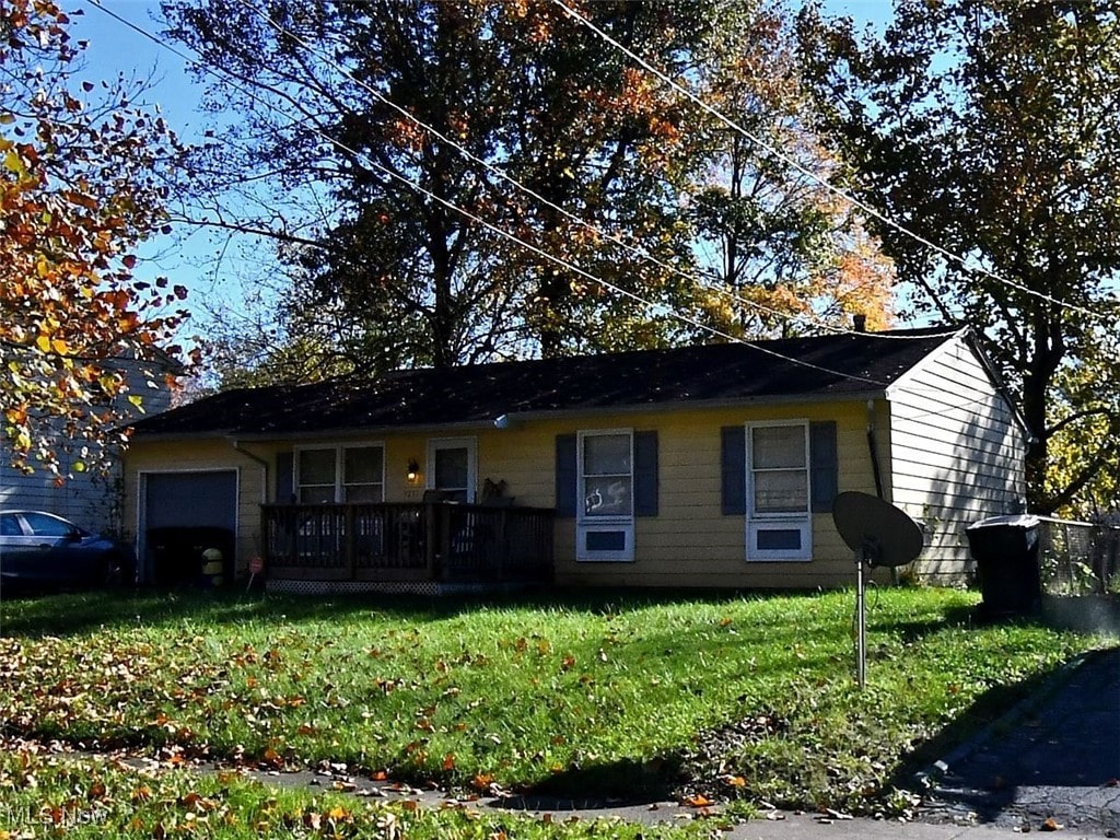 single story home featuring a garage and a front lawn