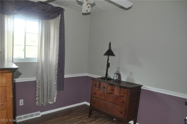 bedroom featuring a textured ceiling, ceiling fan, and dark hardwood / wood-style flooring