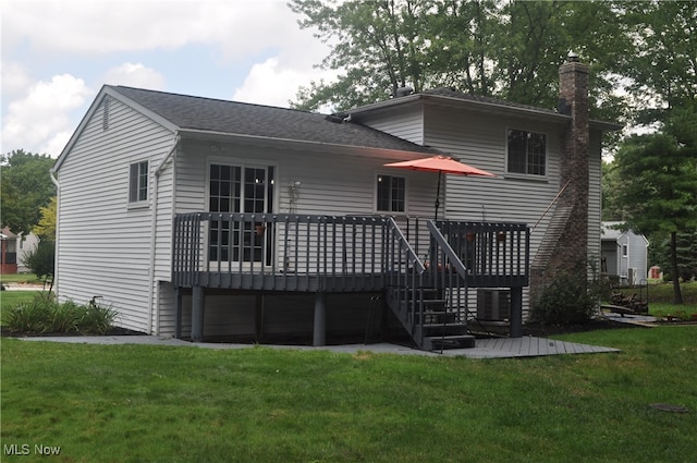 rear view of property featuring a wooden deck and a yard