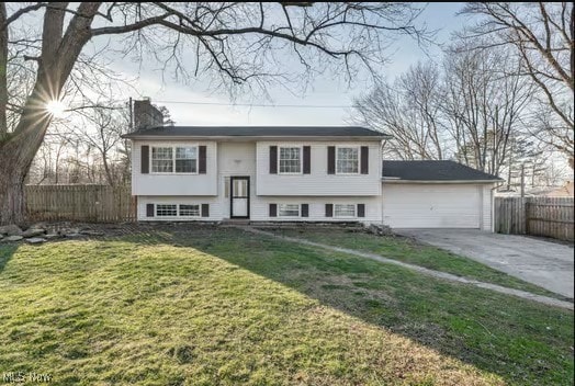 split foyer home featuring a front lawn and a garage