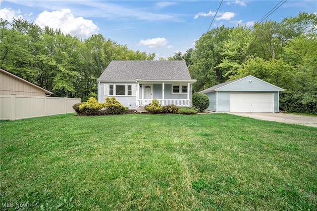 single story home with a front lawn, covered porch, a garage, and an outbuilding