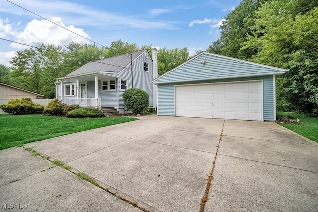 view of front of house featuring a garage, a porch, a front lawn, and an outdoor structure