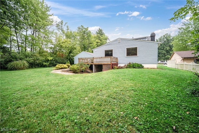 back of property with a wooden deck and a lawn