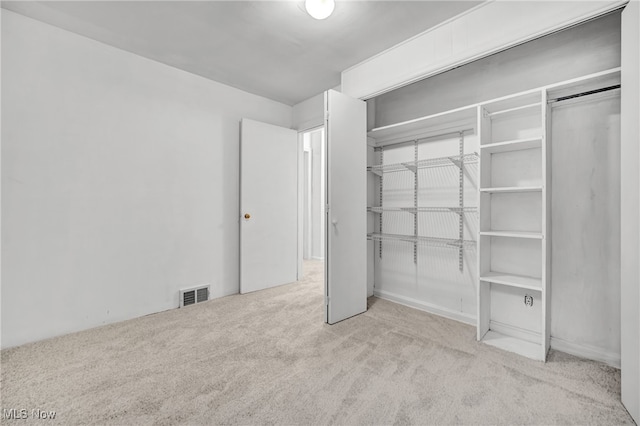 unfurnished bedroom featuring light colored carpet and a closet