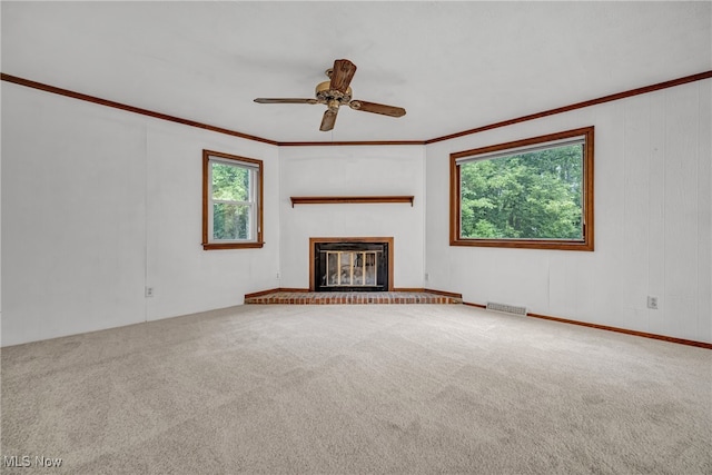 unfurnished living room featuring ceiling fan, crown molding, and carpet