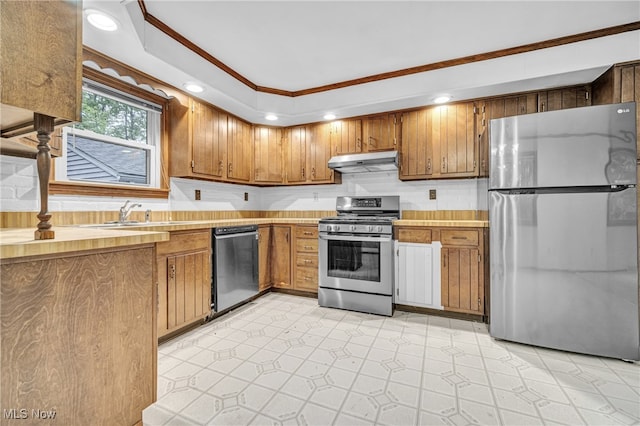 kitchen with appliances with stainless steel finishes, crown molding, light tile patterned flooring, tasteful backsplash, and sink