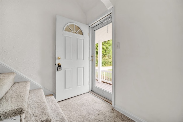 foyer entrance featuring light carpet