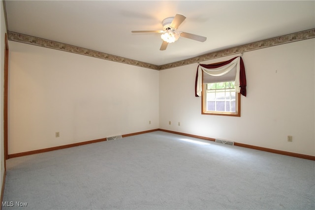 carpeted spare room featuring ceiling fan