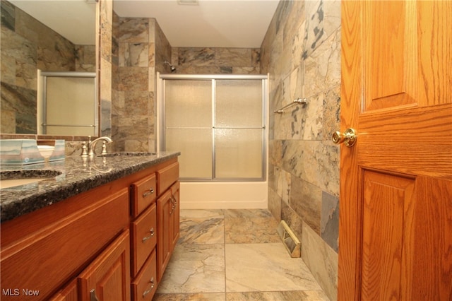 bathroom with tile walls, shower / bath combination with glass door, and tile patterned floors