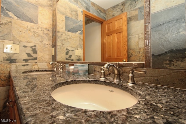 bathroom featuring vanity and tile walls