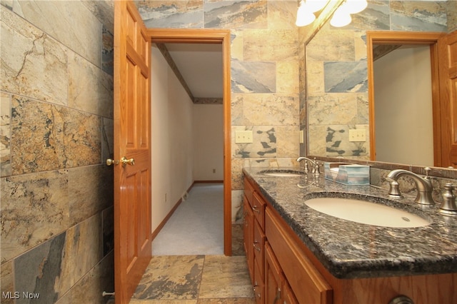 bathroom with tile walls and double vanity