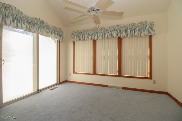 empty room with ceiling fan, vaulted ceiling, and carpet flooring