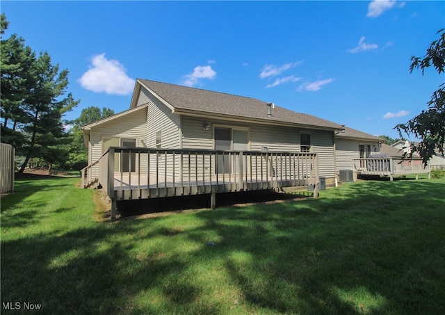 back of property with a yard, a wooden deck, and cooling unit