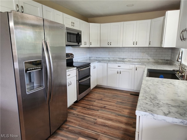 kitchen featuring tasteful backsplash, dark wood-type flooring, stainless steel appliances, and white cabinets