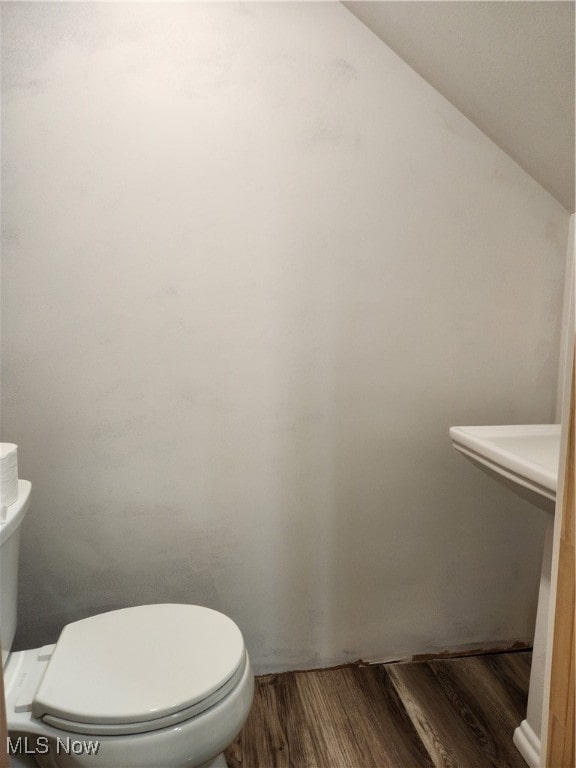 bathroom with toilet and hardwood / wood-style flooring