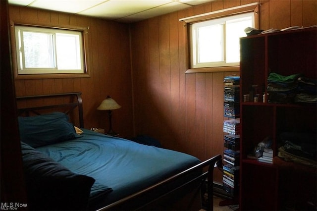 bedroom featuring wood walls