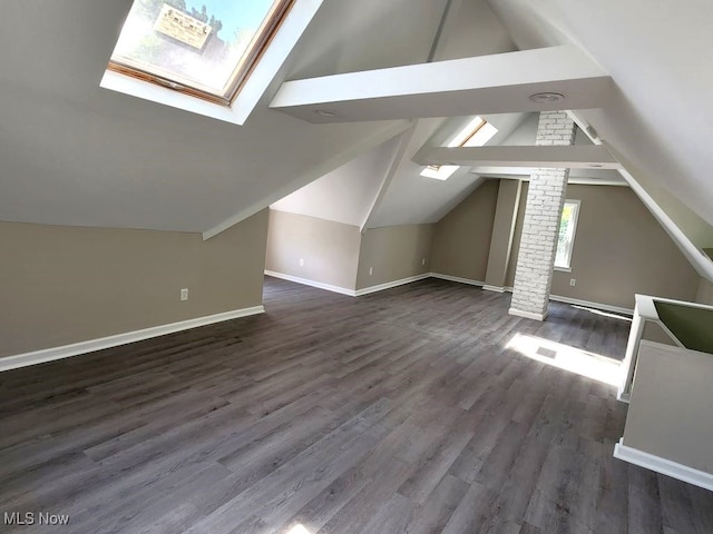 additional living space featuring lofted ceiling with skylight, brick wall, and wood-type flooring