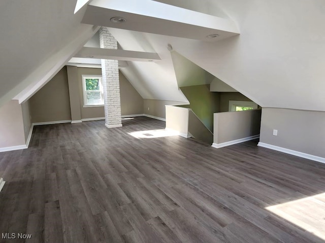 bonus room featuring brick wall, vaulted ceiling, and hardwood / wood-style flooring