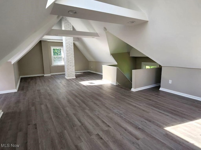 bonus room with vaulted ceiling, dark wood finished floors, and baseboards