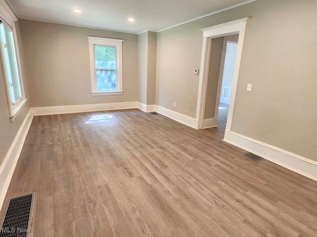 spare room featuring light hardwood / wood-style flooring and crown molding