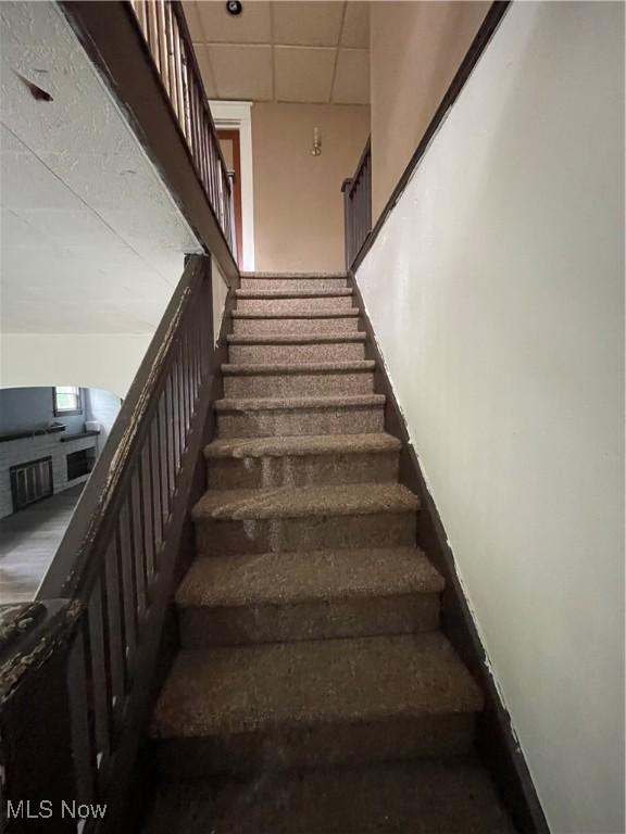 stairway with a paneled ceiling