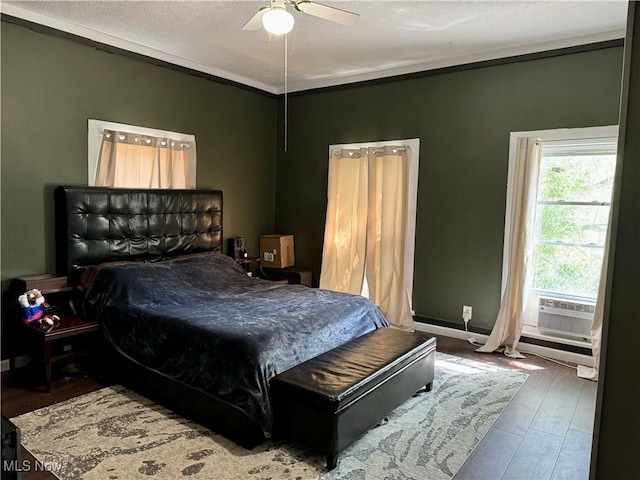 bedroom featuring dark hardwood / wood-style floors, cooling unit, and ceiling fan