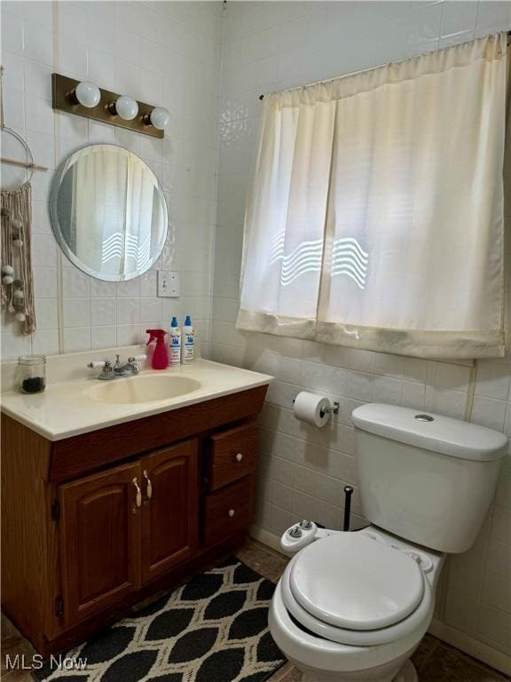 bathroom featuring tile walls, vanity, and toilet