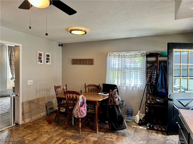 dining room with ceiling fan and a textured ceiling