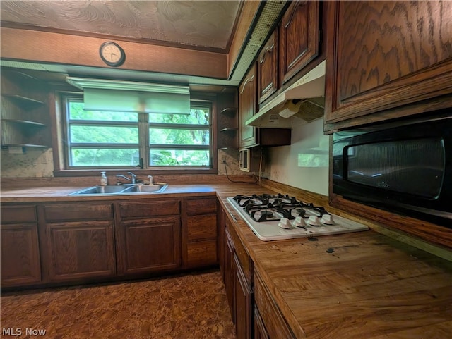 kitchen featuring dark brown cabinets, stainless steel gas stovetop, and sink