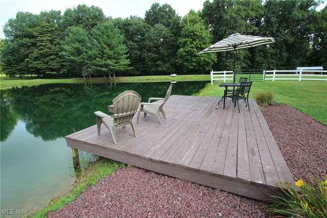 deck with a water view and a lawn