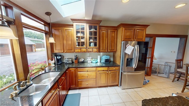 kitchen with a skylight, pendant lighting, sink, stainless steel fridge with ice dispenser, and light tile patterned floors