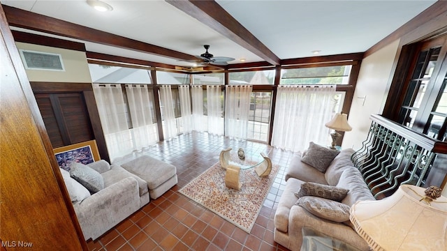 living room featuring beam ceiling, dark tile patterned flooring, and ceiling fan