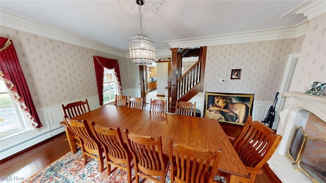 dining area with ornamental molding, a notable chandelier, light wood-type flooring, and a baseboard radiator