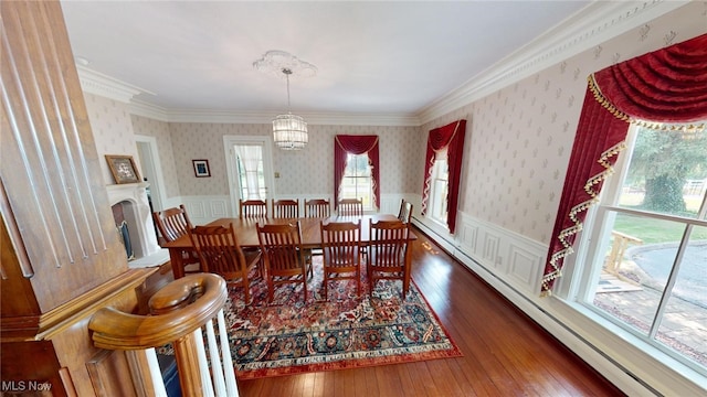 dining space with ornamental molding, a baseboard radiator, an inviting chandelier, and dark hardwood / wood-style floors